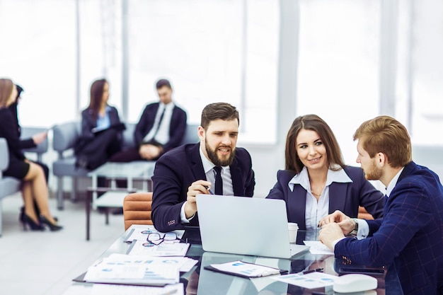 Los empleados de la empresa trabajan en una computadora portátil con información sobre el desarrollo de la empresa.