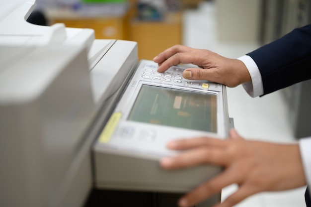 Los empleados están copiando documentos con una fotocopiadora en la oficina.