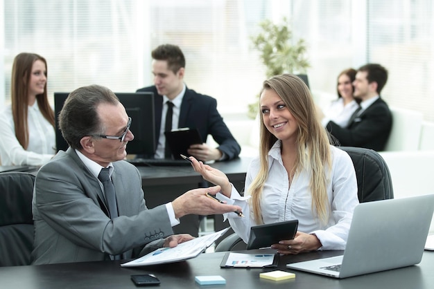 Empleados que usan tableta digital para trabajar con datos financieros