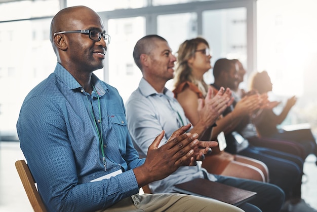 Empleados sentados y aplaudiendo juntos en un seminario y taller exitoso Lugar de trabajo diverso que apoya al personal con una conferencia de capacitación Celebración de relaciones profesionales en los negocios