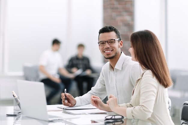 Empleados sentados en una mesa en la oficina.