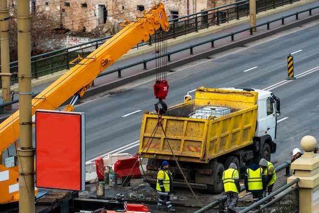 Empleados del servicio de carreteras con chalecos amarillos especiales realizan trabajos en la reparación de la calzada Restauración de la costura de deformación del puente del automóvil