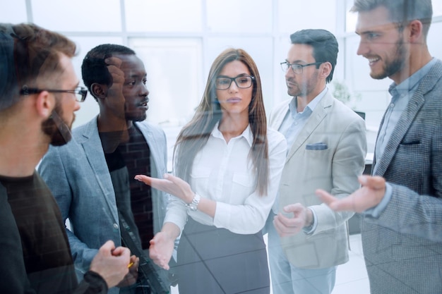 Empleados sonrientes discuten nuevas ideas de pie en la oficina el concepto de trabajo en equipo