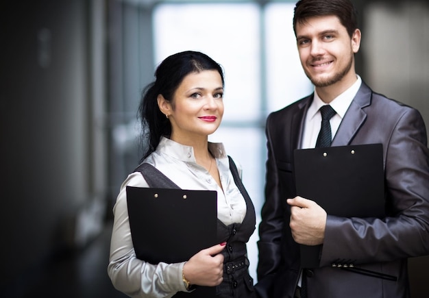 Empleados sonrientes parados en su gerente