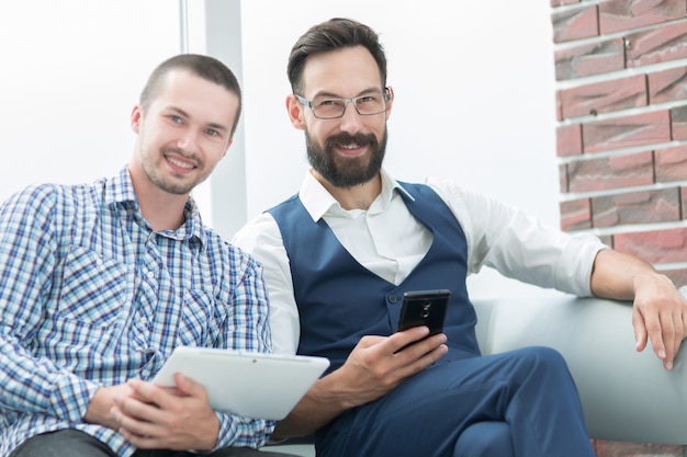 Empleados con sus gadgets sentados en la oficina.