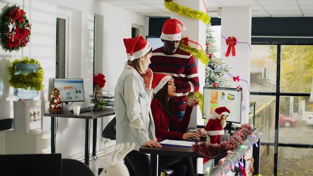 Foto empleados de tormenta de ideas en la oficina de xmas