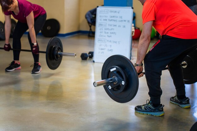 Empoderamiento de las mujeres Entrenamiento de las mujeres en el gimnasio con un entrenador personal