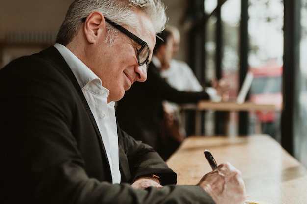 Empreendedor escrevendo uma ideia de negócio em um café