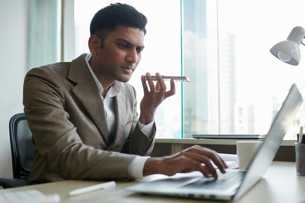 Empreendedor gravando mensagem de voz para colega de trabalho