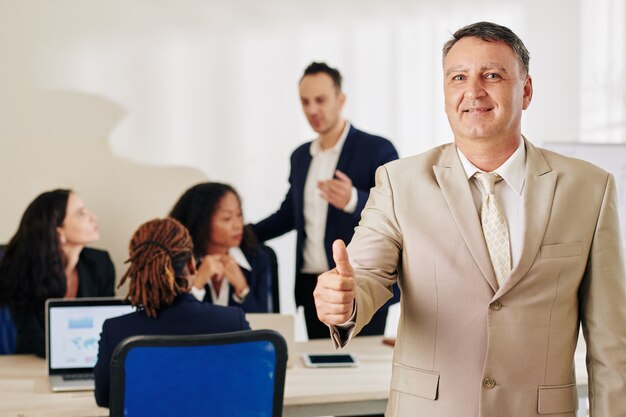 Empreendedor sorridente mostrando o polegar para cima