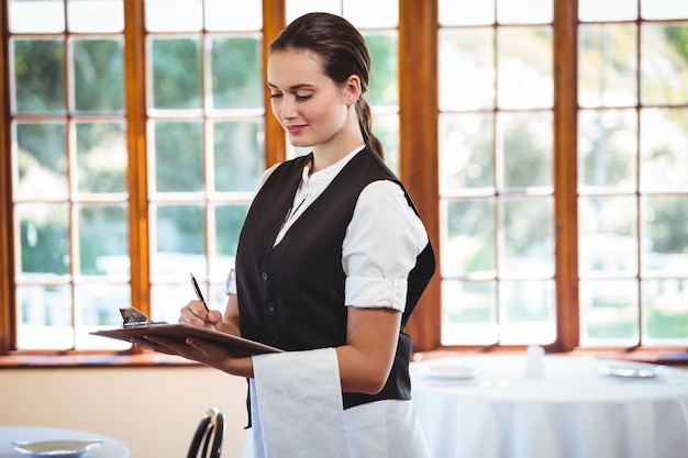 Empregada de mesa usando um tablet