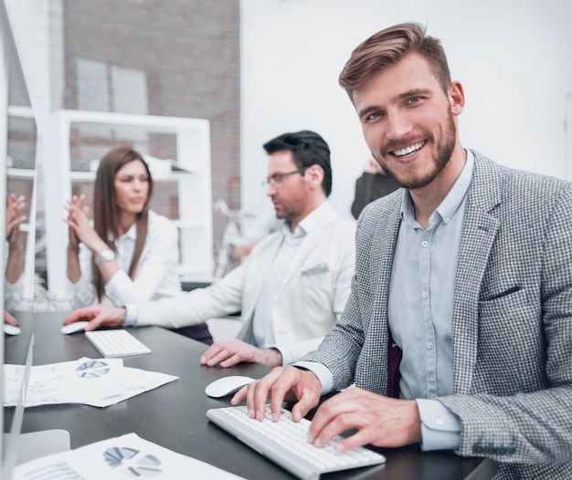 Empregado bem sucedido sentado à mesa no escritório