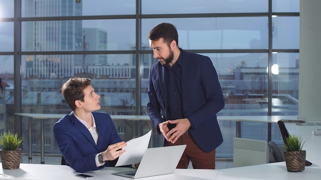 Empregado da empresa traz documentos financeiros para seu chefe