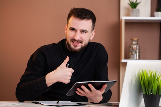 Empregado trabalhando em um tablet no escritório