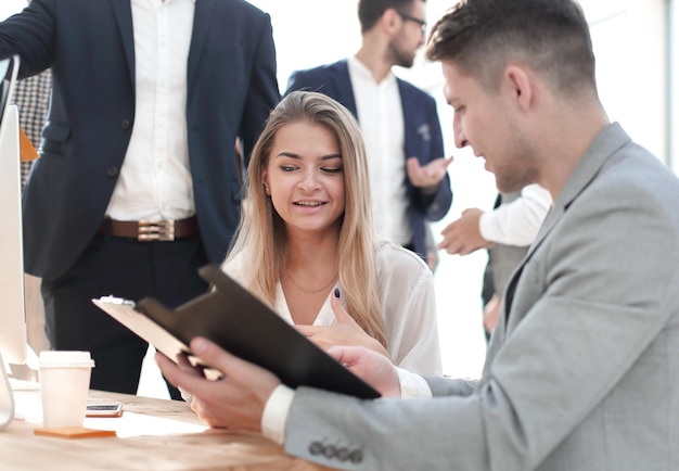 Empregados discutindo documento de negócios sentado na mesa de escritório