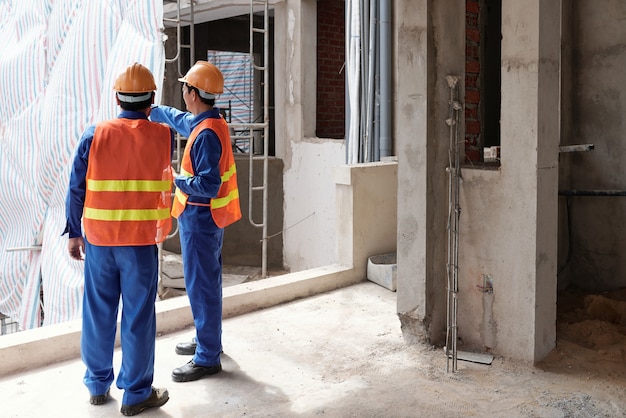 Empreiteiro-chefe mostrando o local ao gerente de construção e explicando as mudanças que sua equipe vai fazer ...