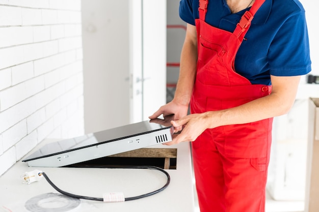 Empreiteiro de serviço jovem montando móveis de cozinha