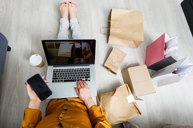 Emprendedor de una pequeña empresa con una computadora portátil, un hombre independiente que trabaja en una caja, un joven empresario asiático en la oficina en casa, una caja de empaquetado de marketing en línea y una entrega, concepto de entrega de PYMES de tecnología