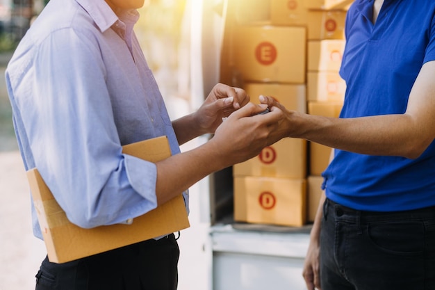 Emprendedor de pequeñas empresas o mujer asiática independiente que usa una computadora portátil con caja Mujer asiática de éxito joven con su mano levanta la caja de embalaje de marketing en línea y el concepto de PYME de entrega