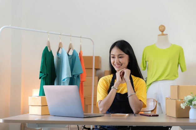 Emprendedor de pequeñas empresas PYME mujer asiática empacando tela en caja Retrato joven propietario de una pequeña empresa asiática oficina en casa venta en línea marketing entrega PYME comercio electrónico concepto de telemarketing