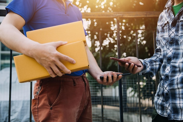 Emprendedora de una pequeña empresa nueva de una mujer asiática independiente que usa una computadora portátil con una caja Éxito alegre Mujer asiática su mano levanta la caja de empaque de marketing en línea y entrega el concepto de idea de PYME