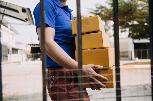 Foto emprendedora de pequeñas y medianas empresas de nueva creación de una mujer asiática independiente que usa un delantal que usa una computadora portátil y una caja para recibir y revisar pedidos en línea para prepararse para empacar ideas de negocios para vender a los clientes en línea