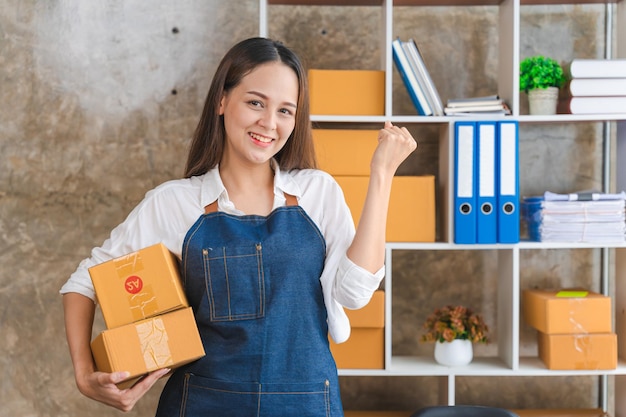 Emprendedoras Pequeñas empresas PYME Mujeres asiáticas jóvenes felices después de un nuevo pedido del propietario del negocio del cliente que trabaja en la oficina en casa Compras en línea Empresario de PYME o concepto de trabajo independiente