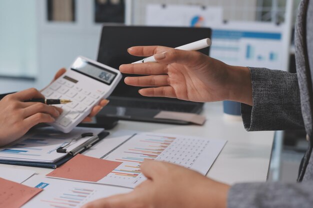 La empresa contable proporciona planificación financiera e impositiva para un flujo de efectivo rentable El equipo de auditores y contadores que trabaja en la oficina analiza los datos financieros y el registro contable con la calculadora Insight