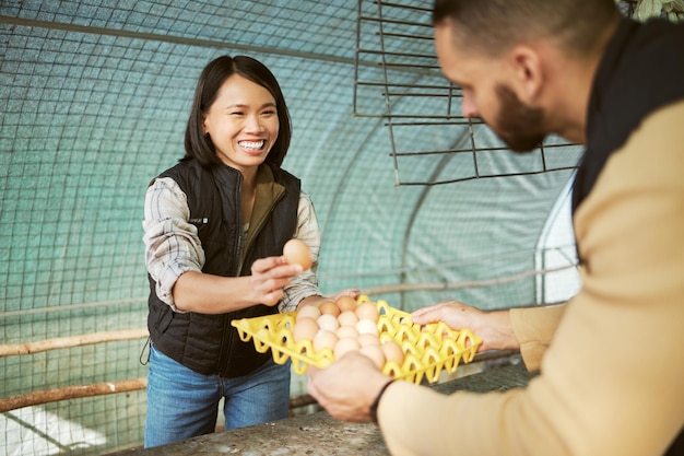 Empresa de alimentos para produção de ovos e mulher asiática feliz com o crescimento de agricultura ecológica de ovos Sustentabilidade do agricultor de galinhas e verificação de produtos agrícolas de um trabalhador em um galinheiro com um sorriso