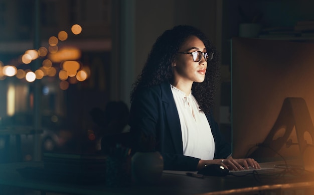 Empresa de escritório e mulher negra no computador para gerenciamento de projetos de pesquisa e online à noite Visão do gerente corporativo e trabalhadora trabalhando até tarde no planejamento estratégico e lendo o site