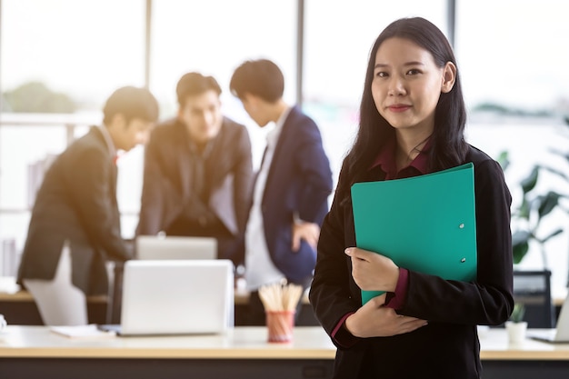 Empresa exitosa, ejecutiva Joven empresaria asiática con carpeta de archivos de retención con trabajadores felices Grupo de empresarios asiáticos con diversos géneros (LGBT) en la sala de reuniones en la oficina