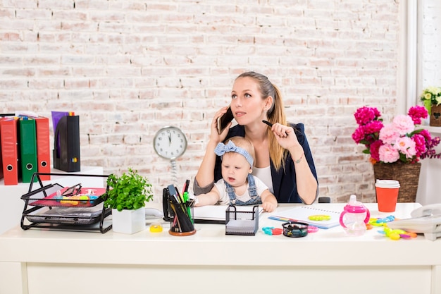 Empresa familiar - empresaria a distancia y la madre con el niño está haciendo una llamada telefónica