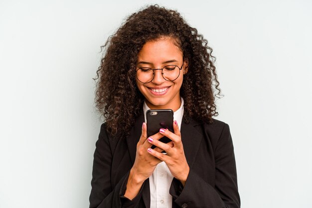 Empresa joven mujer brasileña sosteniendo teléfono móvil aislado sobre fondo blanco.