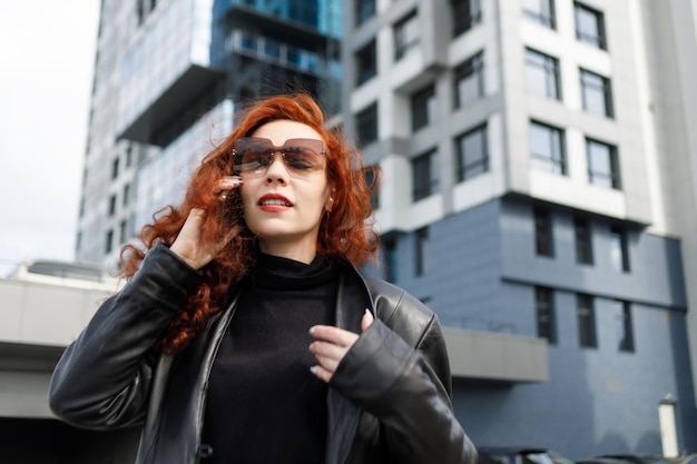 Una empresaria adulta en una gran ciudad Hablando por un teléfono móvil y sonriendo