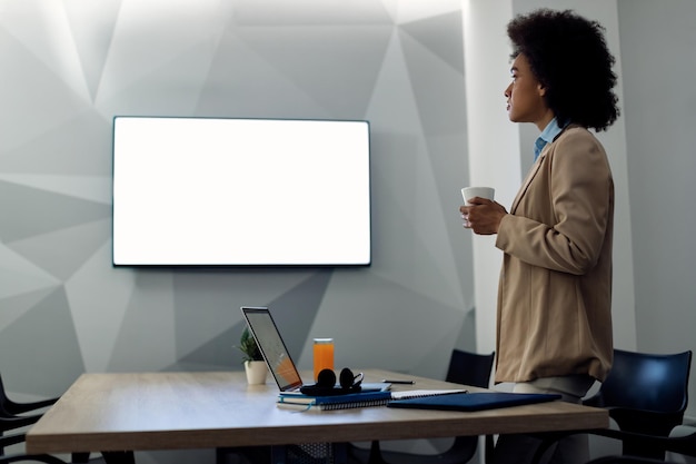 Foto empresária afro-americana tendo uma teleconferência enquanto trabalhava no escritório