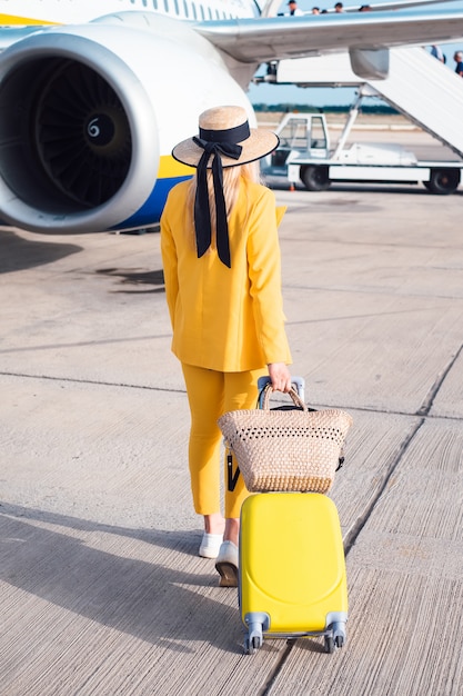 Empresaria en amarillo permanecer cerca del avión