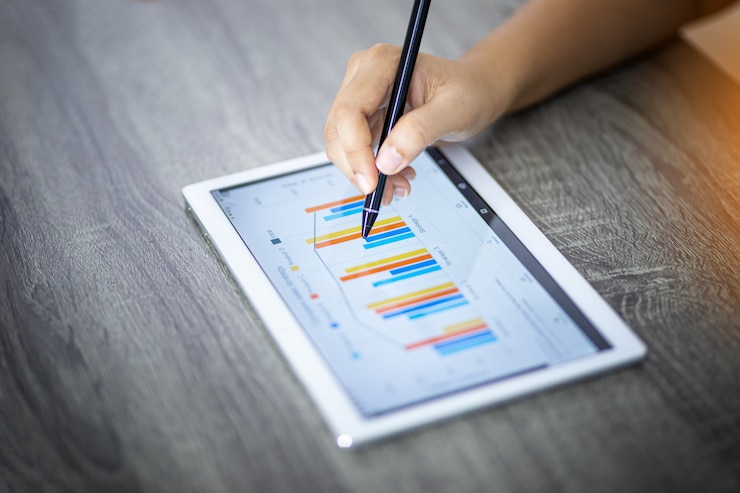 Foto empresaria analizar gráficos en una tableta digital en una oficina