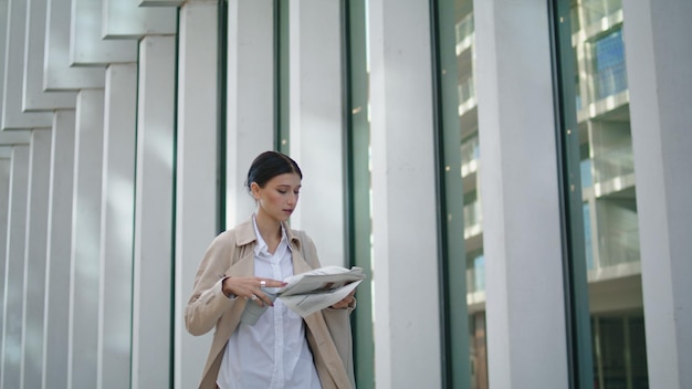 Empresária andando lendo jornal na rua garota segurando a imprensa matinal