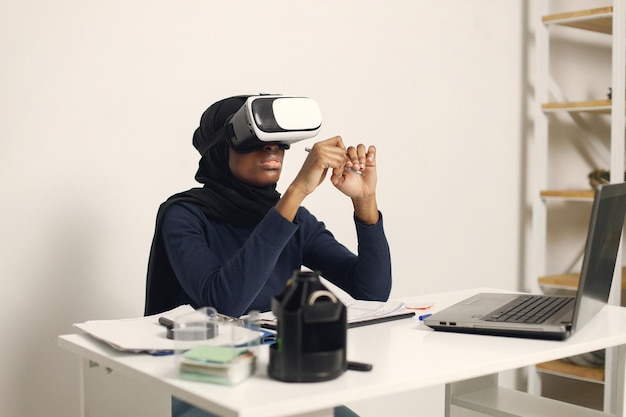 Empresaria árabe en su oficina con gafas de realidad virtual