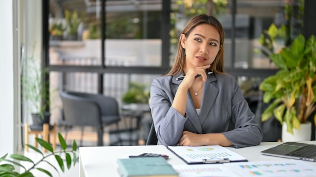 Empresária asiática confiante ponderando e pensando no plano de estratégia de negócios