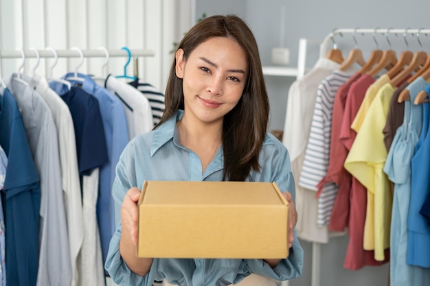 Empresária asiática embalando panos em caixa para entrega. negócio de vendas online e e-commerce.