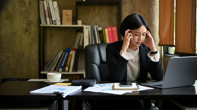 Empresária asiática estressada e séria pensando pensativamente em soluções de problemas