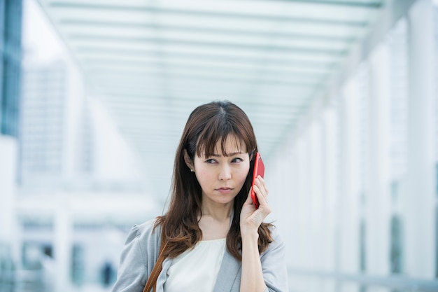 Empresaria asiática hablando en el teléfono inteligente