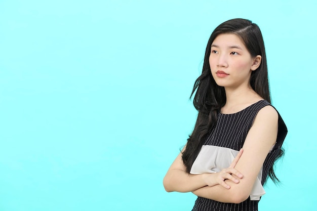 Empresária asiática no poder posar profissional de negócios cruza os braços no peito em pé fundo azul