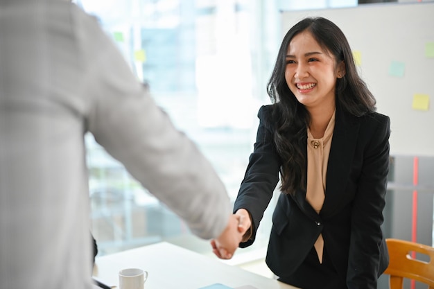 Empresaria asiática profesional estrechando la mano de un hombre de negocios