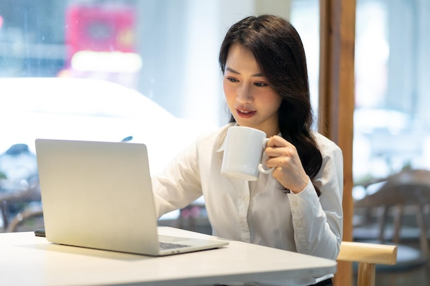 Empresaria asiática que trabaja en un café