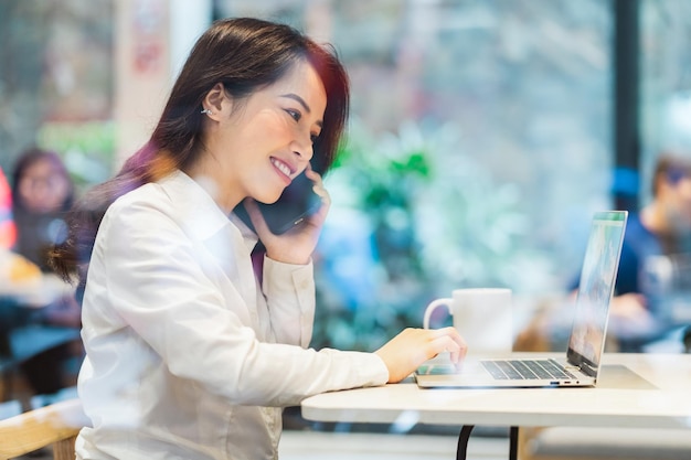 Empresaria asiática que trabaja en un café