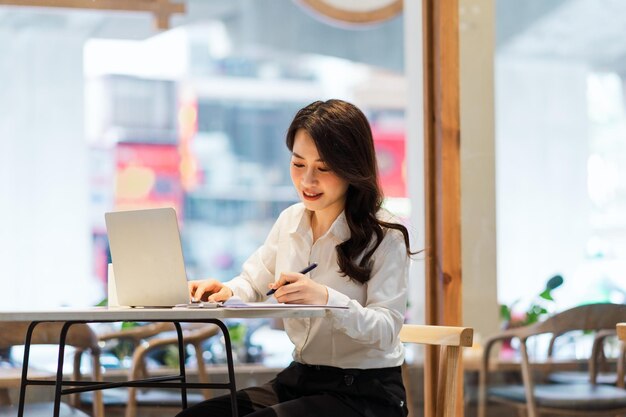 Empresaria asiática que trabaja en un café