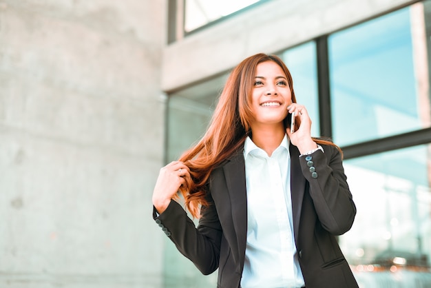 Foto empresaria asiática que usa la cara del smie del smartphone