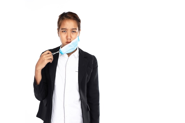 Foto empresaria asiática con rostro serio se quita la mascarilla quirúrgica con una mano con chaqueta de traje negro, mira a la cámara, aislada sobre fondo blanco, coronavirus, covid19